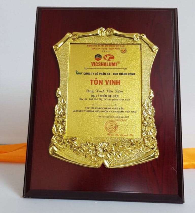 Nguyên tắc phối nền gỗ, màu vàng, logo và nội dung trên bảng vinh danh